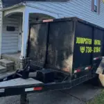 10‑yard rubber‑wheeled dumpster trailer from United Rent a Dumpster at a residential cleanout project in Clinton Township, Michigan.